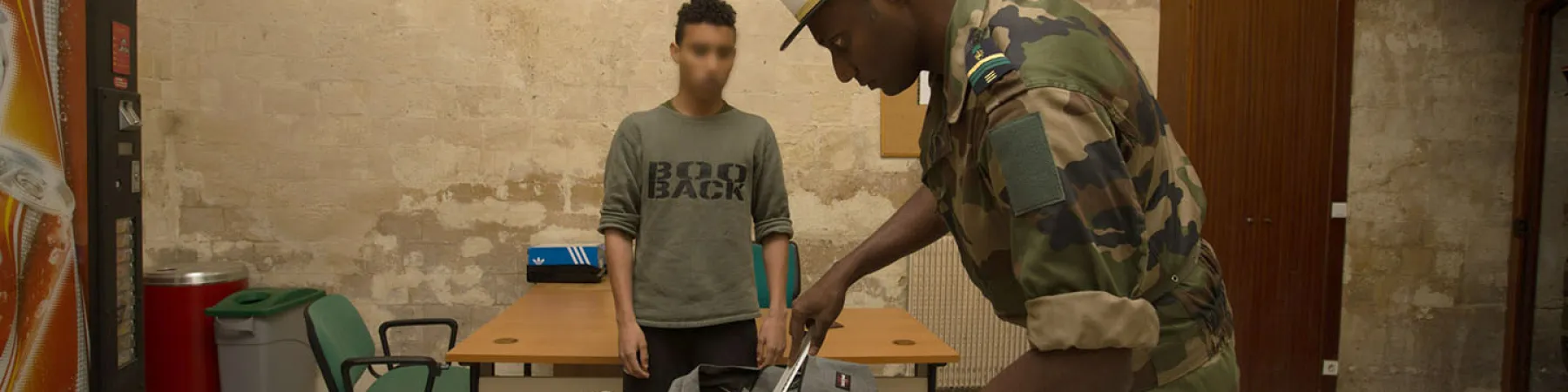 Un homme vérifie les affaires emmenées par un soldats